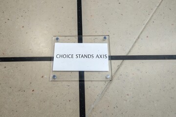 Transparent acrylic plaque with Choice Stands Axis text on floor