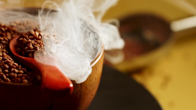 Buckwheat groats in a wooden bowl with steam rising in a cozy kitchen setting