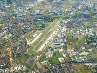 Landscape of the international airport of the town of Bergamo in Italy. View from the window of the airplane. Aerial landscape