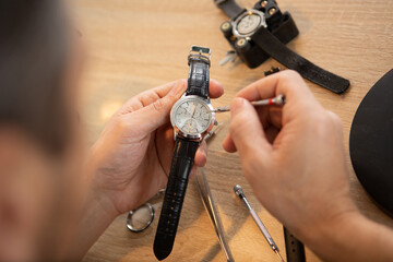 cropped close up of a watchmaker fixing vintage mechanical watch