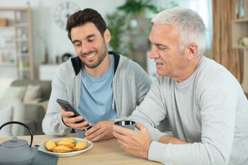 cheerful father son middle age eating homemade cookies