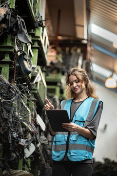 Portrait Caucasian woman engineer or mechanic use tablet computer checking auto part or car part at car part warehouse	