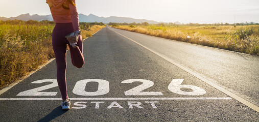 New year 2026 or start straight concept.word 2026 written on the asphalt road and athlete woman...
