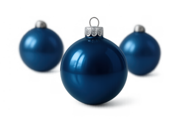 Blue glass christmas ornament in front with two blurry baubles in background, celebrating winter holiday season, transparent background