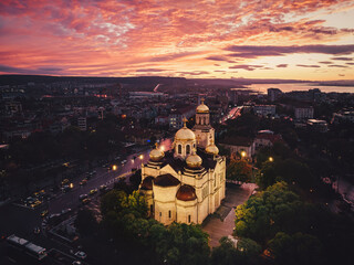 Dramatic sunset over Varna city, Varna lake and temple building The Cathedral of Assumption aerial panorama above downtown