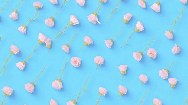 Delicate pink flower buds scattered across a vibrant blue background create a cheerful and visually appealing floral pattern, perfect for various design projects.