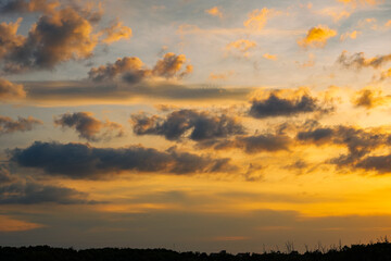 Fototapeta premium Sunset sky clouds in the Evening with Golden orange sunlight in golden hour, Dusk sky background