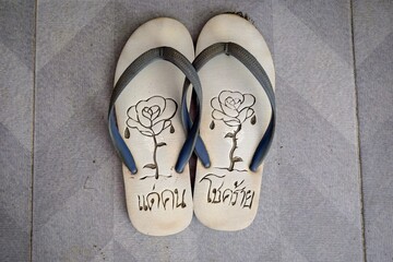 This image captures a piece of everyday Thai culture, combining utility with personal, local design and language. It is ideal for themes related to Southeast Asia, travel, footwear, casual lifestyle, 