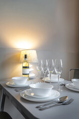 Elegant Table Setting with Wine Bottle and Warm Lamp Light