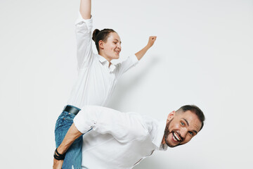 A professional man in business attire stands against a solid colored background, displaying...
