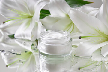 delicate jar of beauty cream sits on a reflective surface next to fresh white lilies, creating a calm atmosphere perfect for relaxation and self-care