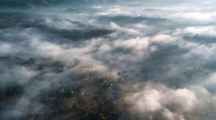 Aerial view of misty mountains and clouds at sunrise.
