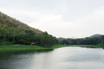 Tranquil view of Khao Ruak Reservoir and the small bungalow accommodation area within Namtok Sam Lan National Park, a popular spot for camping and relaxation in Saraburi, Thailand