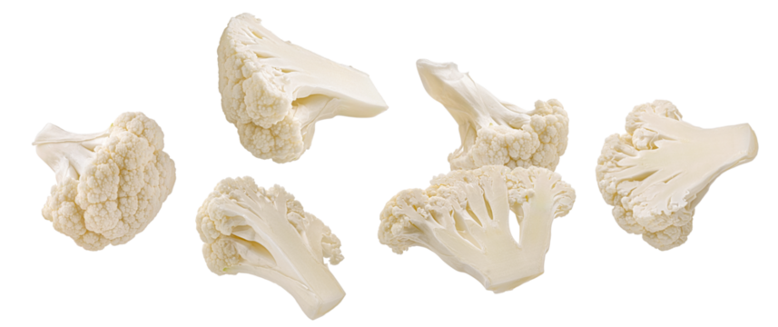 realistic photograph of a dense grouping of fresh, crisp white cauliflower florets and chunks, showcasing the texture and isolated cleanly on a solid black backdrop.
