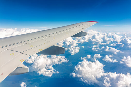 View from the airplane window at a beautiful cloudy sky and the airplane wing