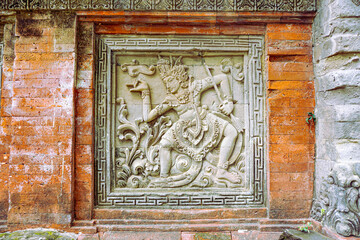 Ancient Balinese stone carving depicting a mythical warrior in action