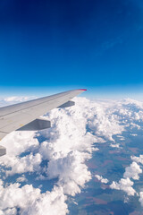 Fototapeta premium View from the airplane window at a beautiful cloudy sky and the airplane wing