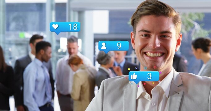 Smiling man wearing gray suit standing in office lobby, with digital social media icons, copy space