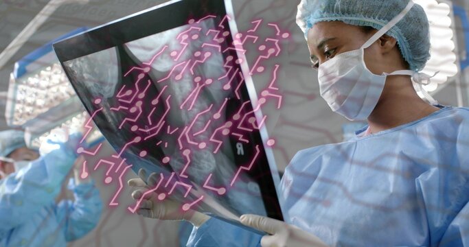 Holding radiograph surgeon wearing gown under lights in OR, with pink circuit overlay, copy space
