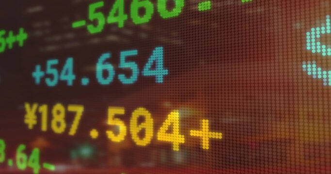 Displaying colored numeric stock data on LED display on trading floor, featuring financial digits