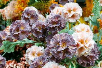 Pastel and purple artificial flowers with ruffled petals in floral display. Faux blooms, sustainable decor, romantic styling, low-maintenance design