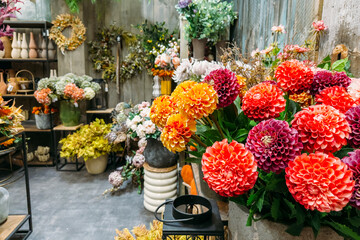 Colorful artificial dahlias arranged in a rustic boutique floral display. Visual realism, consumer design culture, plastic waste, decor overproduction