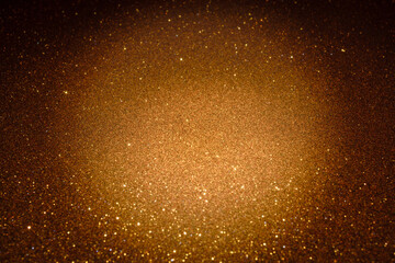 Golden glitter texture sparkling under warm light, creating shimmering abstract surface with glowing highlights and subtle depth across frame