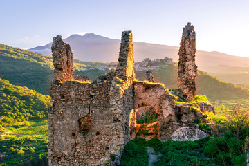 golden beautiful sunset landscape of mountain peak with ancient fortrees ruin on the top and...