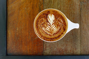 a cup of latte art coffee on wooden background                                                     ...