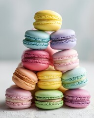Obraz premium Colorful stacked macarons on a soft background creating a sweet and inviting dessert display