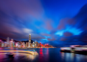 Nighttime abstract view of Hong Kong with radial blur effect, city lights, and dramatic skies. This captures the energy of a vibrant metropolis.