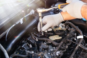 Car mechanic working with motor of a car.