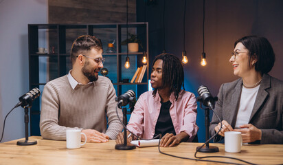 Content creators recording a new podcast episode in a professional studio, discussing and sharing their ideas with microphones