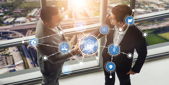 Two business professionals engage in a strategic discussion with digital security icons representing connectivity and technology in a modern office environment. Tessel