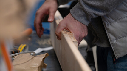 Real life hands working with wood plank in carpentry project