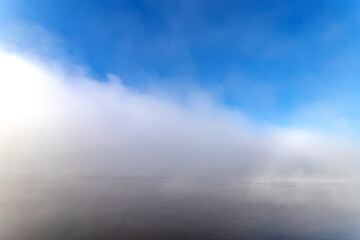Obraz premium Fog over the water in the sunny autumn day