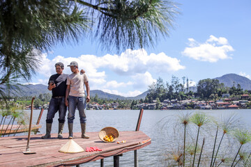 Two Farmers Checking Their Phone on Dock Overlooking Stunning Lake View