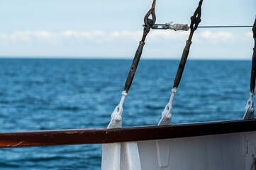 Sailboat rigging against a calm blue sea on a clear sunny day