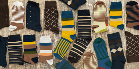 Lots of men's socks on a wooden background. Panorama of socks. Clothing for fall and winter.