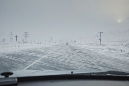 Winter road with a snowstorm and strong winds