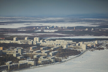 Obraz premium Urban landscape in winter against the backdrop of lakes and cloudy skies during the day. City in the Arctic