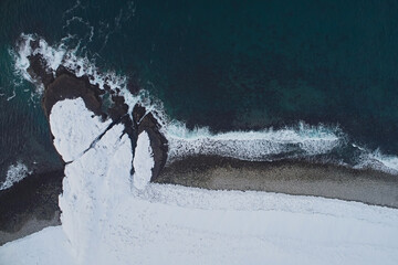 Aerial view of the coast of a non-freezing sea with snow in winter © ILIA
