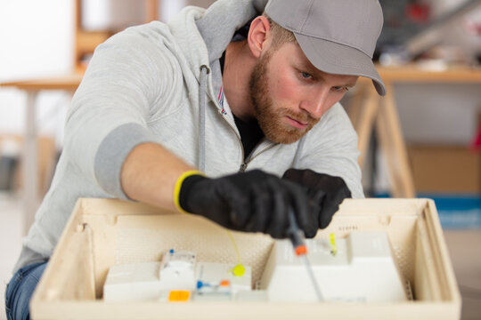 young energetic male tech or engineer repairs electronic equipment