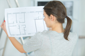thoughtful female architect looking on blueprint