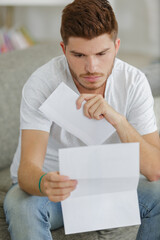 young man at home reading letter