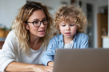 Mother helping child with online learning via laptop at home