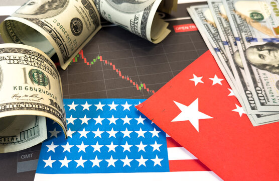 100 dollars and 100 yuan on a US and China flags background. US and China trade and tariffs war. Economic crisis, inflation, customs and commodity prices concept. Economic inflation, deflation or sta