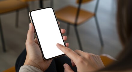 Person holding smartphone with blank white screen indoors using finger.