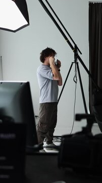 A photographer conducts a masterclass in a studio, explaining how to hold a camera correctly. An educational scene demonstrating professional technique and instruction.