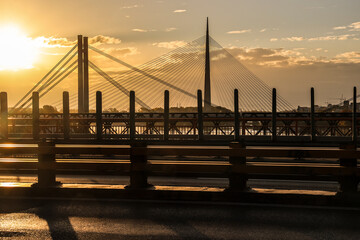 sunset evening red blue orange sky, and blur blurred cars came and went on Ada bridge View from Gazela bridge New Old railway bridge
